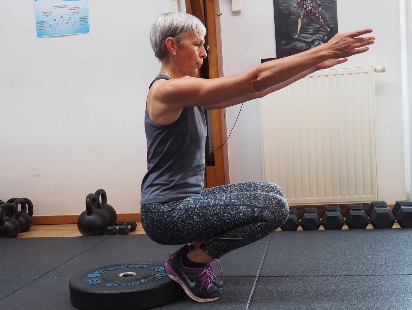 Une sportive en plein squat avec une barre