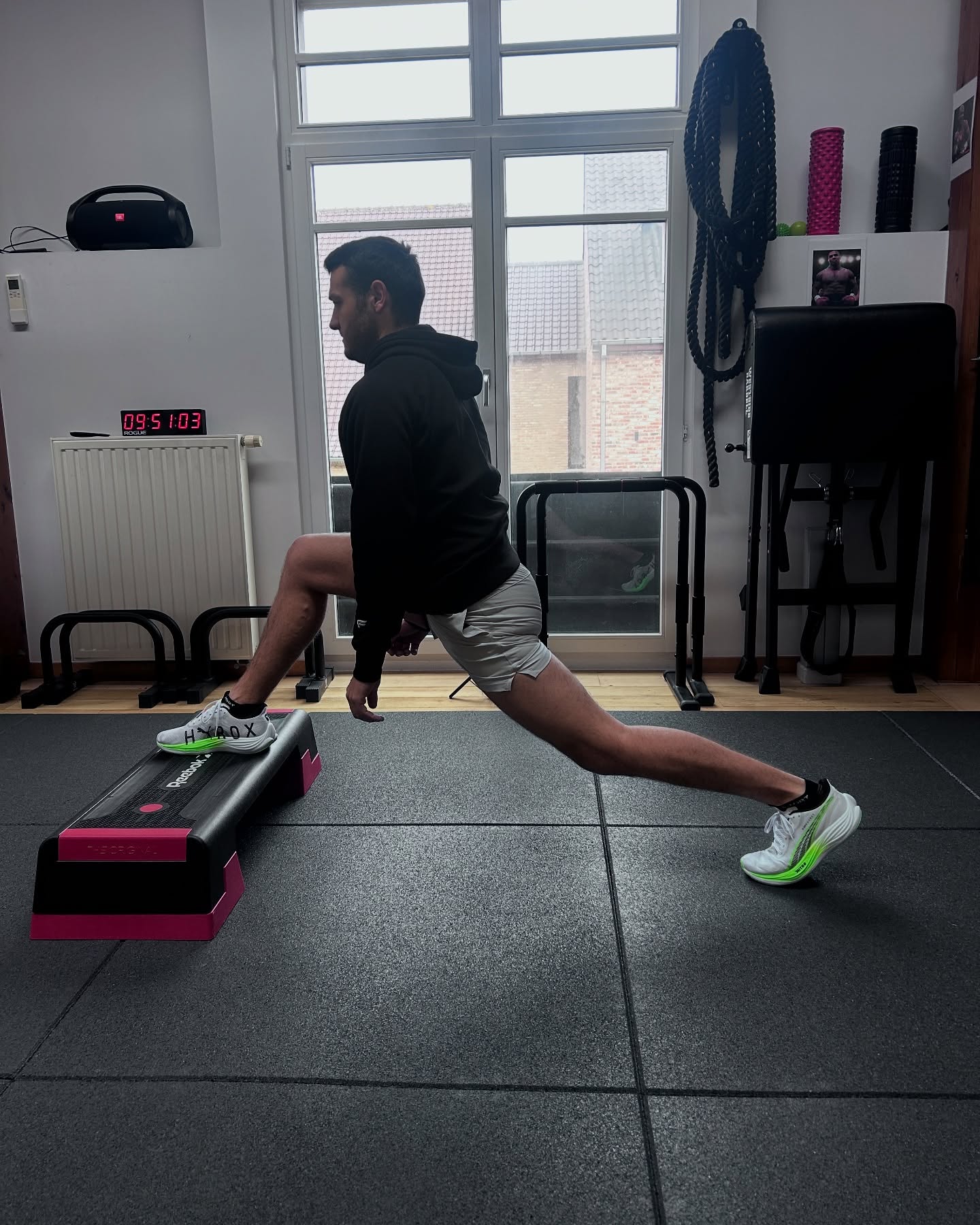 Un sportif en fente sur un step lors d'une séance de mobilité